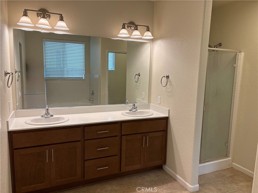 1442 Dynes Street Merced, CA 95348 - Photo 4 of 7 a bathroom with a double vanity sink and a mirror