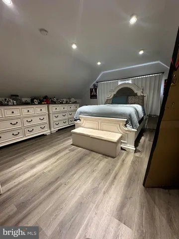 a spacious bedroom with a bed and a dresser