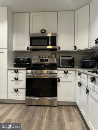 a kitchen with stainless steel appliances a stove a microwave and cabinets
