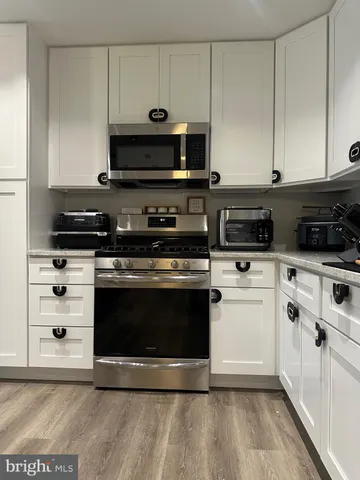 a kitchen with stainless steel appliances a stove a microwave and cabinets