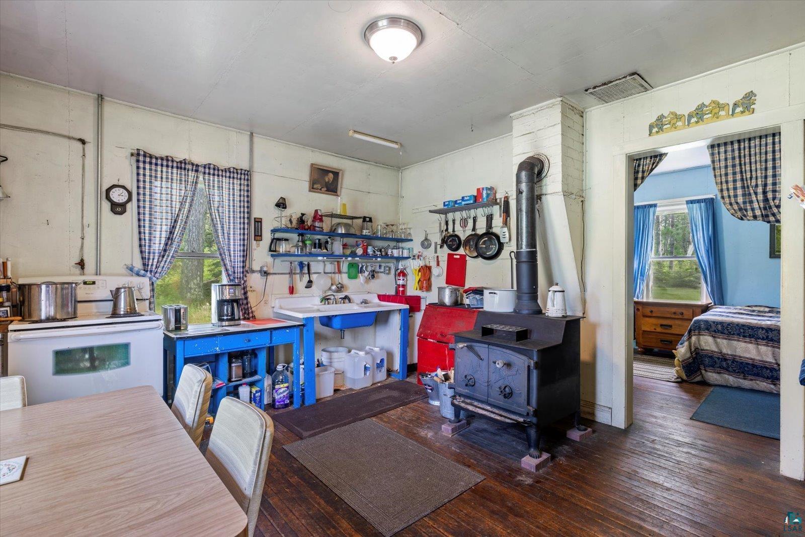 480 Rikala Brimson, MN 55602 - Photo 22 of 38 Kitchen with white electric stove, wood-type flooring, and a wood stove