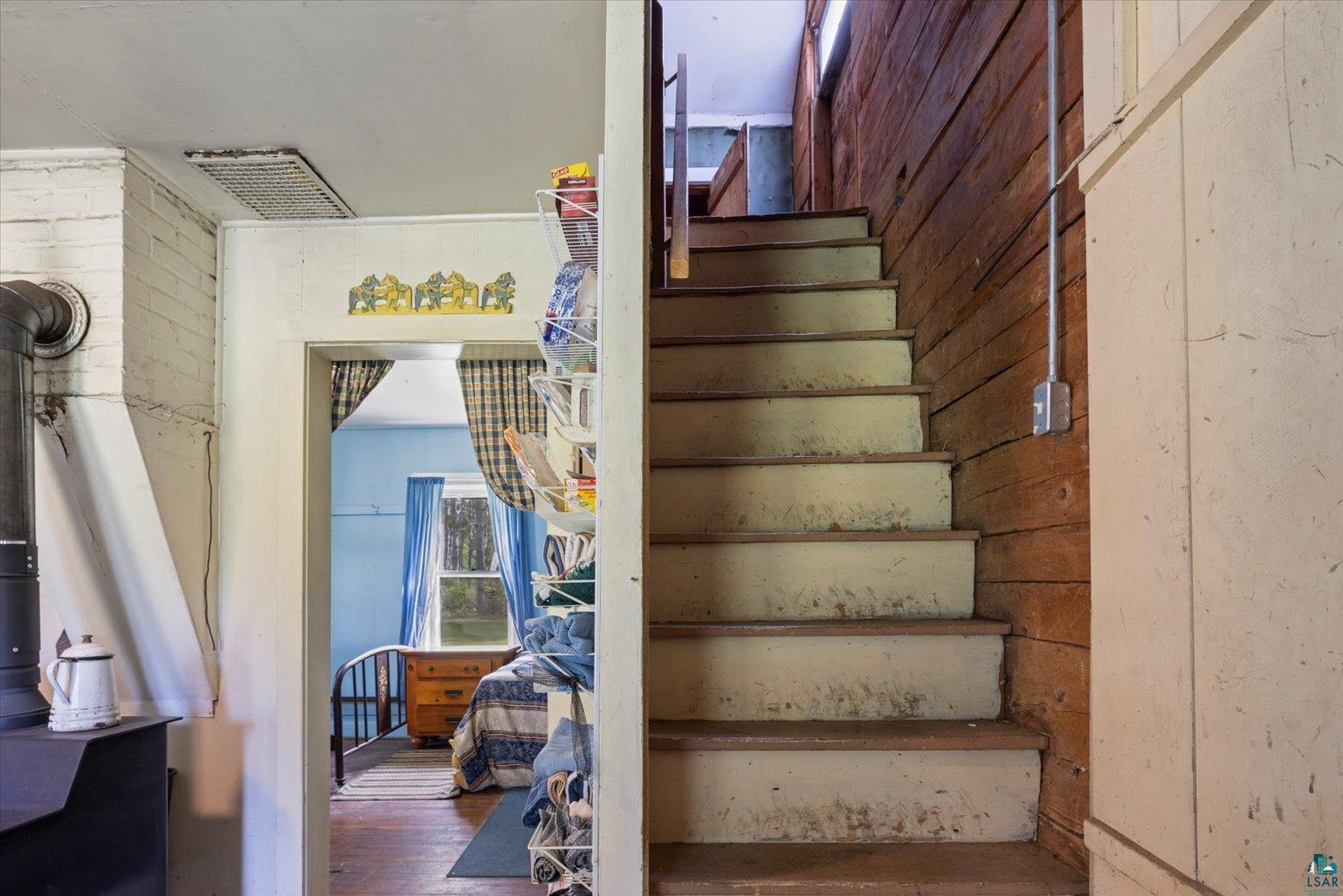 480 Rikala Brimson, MN 55602 - Photo 29 of 38 Stairs featuring wood finished floors, wooden walls, and a wood stove