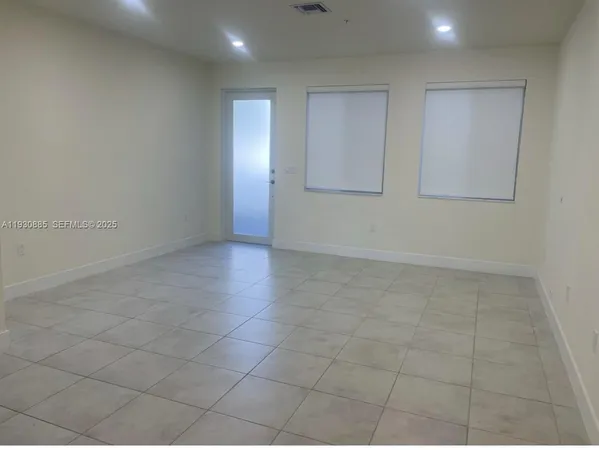 an empty room with white walls and tiles