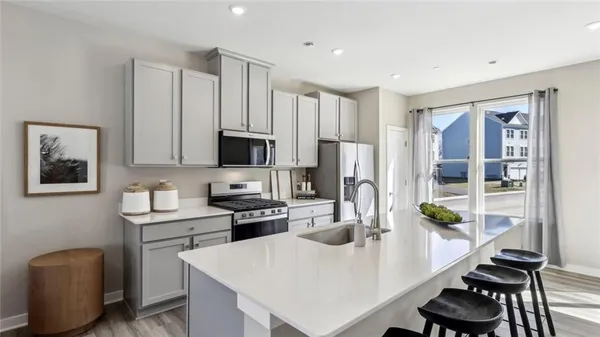a kitchen with a dining table chairs refrigerator and microwave