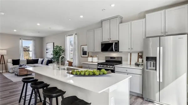 a kitchen with counter top space stainless steel appliances and wooden floor