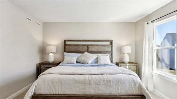 a bedroom with a bed and a large mirror