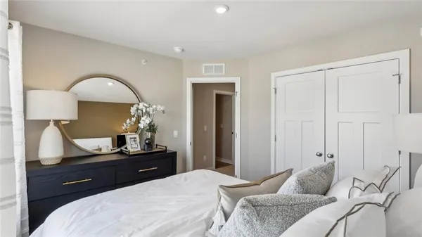 a bedroom with a bed and large windows