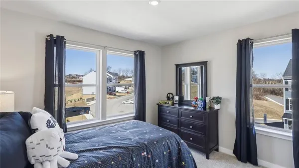 a bed sitting in a bedroom next to a window