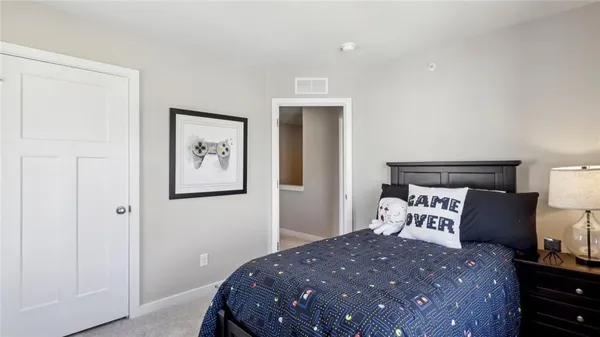 a bedroom with a bed and a painting on the wall