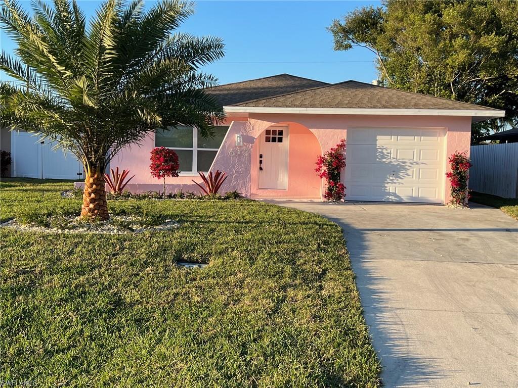 673 107th Avenue North Naples, FL 34108 - Photo 1 of 15 a front view of a house with garden
