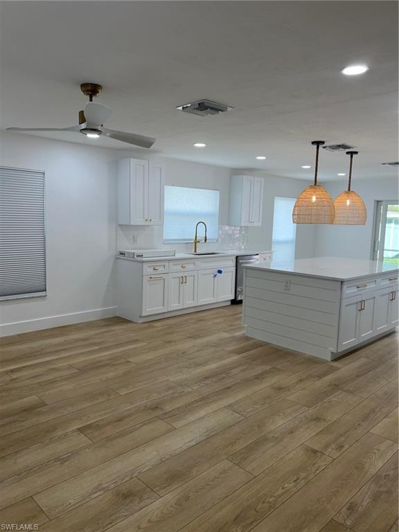 673 107th Avenue North Naples, FL 34108 - Photo 4 of 15 a large white kitchen with kitchen island a sink stainless steel appliances and cabinets