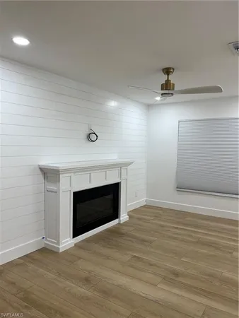 an empty room with wooden floor and fireplace