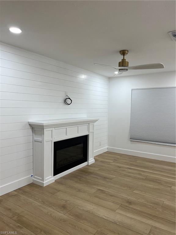 673 107th Avenue North Naples, FL 34108 - Photo 5 of 15 an empty room with wooden floor and fireplace