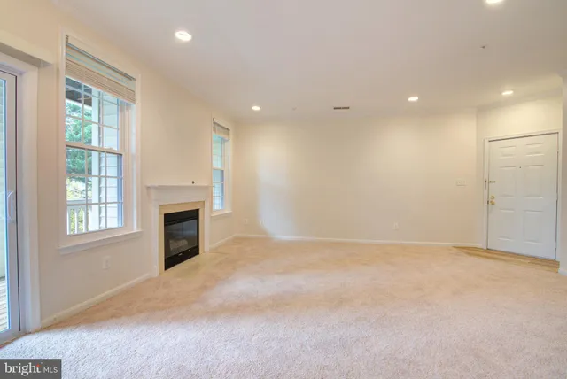 a view of empty room with a fireplace and windows