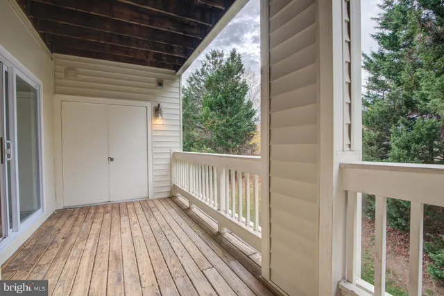 a view of a porch with wooden floor and fence