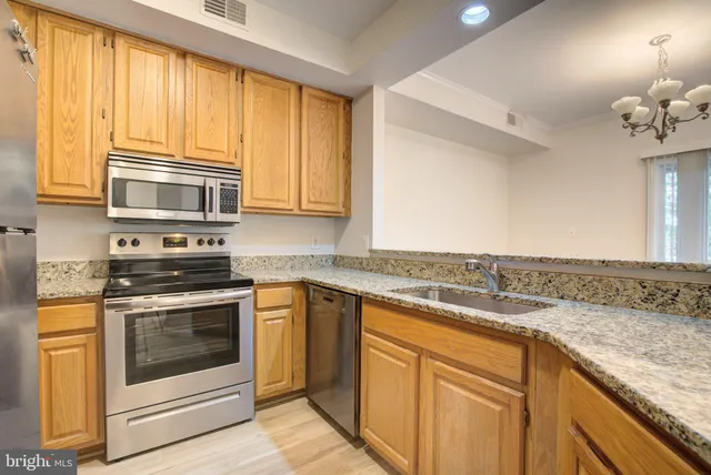 a kitchen with granite countertop cabinets stainless steel appliances and a window