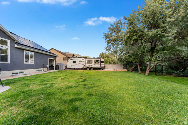 313 Old Maple Road South Weber, UT 84405 - Photo 29 of 35 Expansive grassy yard with mature trees and a dark gray stucco exterior