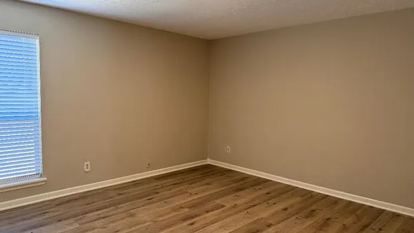 a view of an empty room with wooden floor