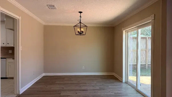 a view of hallway with wooden floor and chandelier
