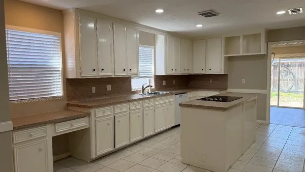 a kitchen with granite countertop white cabinets and white appliances