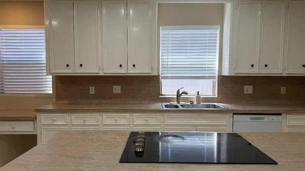 a kitchen with granite countertop white cabinets and a stove