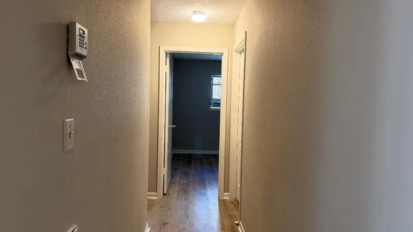 a view of a hallway with wooden floor