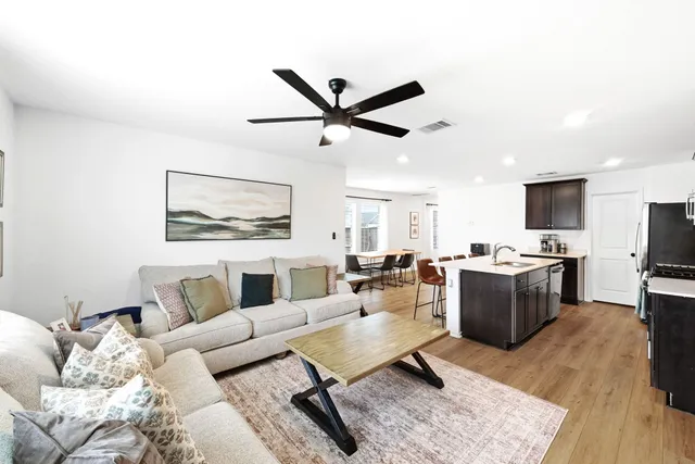 a living room with furniture kitchen view and a window