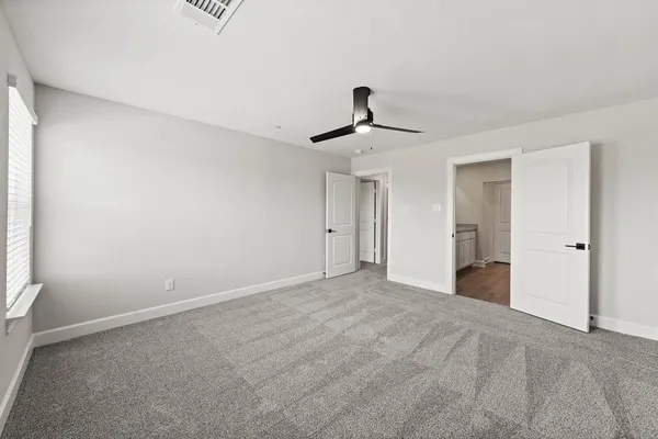 a view of a room with a ceiling fan and window