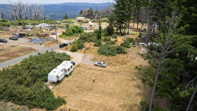 an aerial view of a house with a yard and mountain view in back