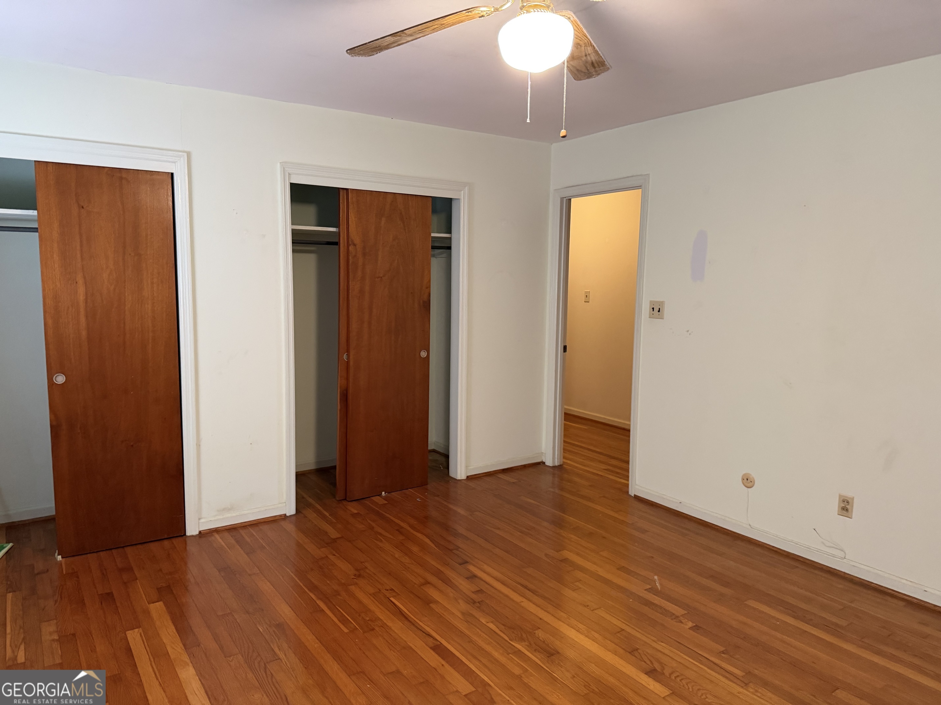 1112 Old Dalton Road Northeast Rome, GA 30165 - Photo 15 of 27 an empty room with wooden floor and a ceiling fan