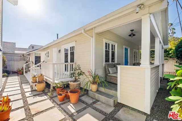 a view of a patio with couches table and chairs and potted plants