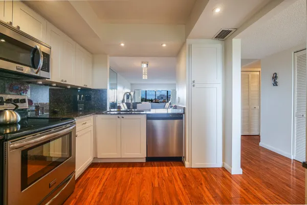 a kitchen with stainless steel appliances granite countertop a refrigerator and a sink