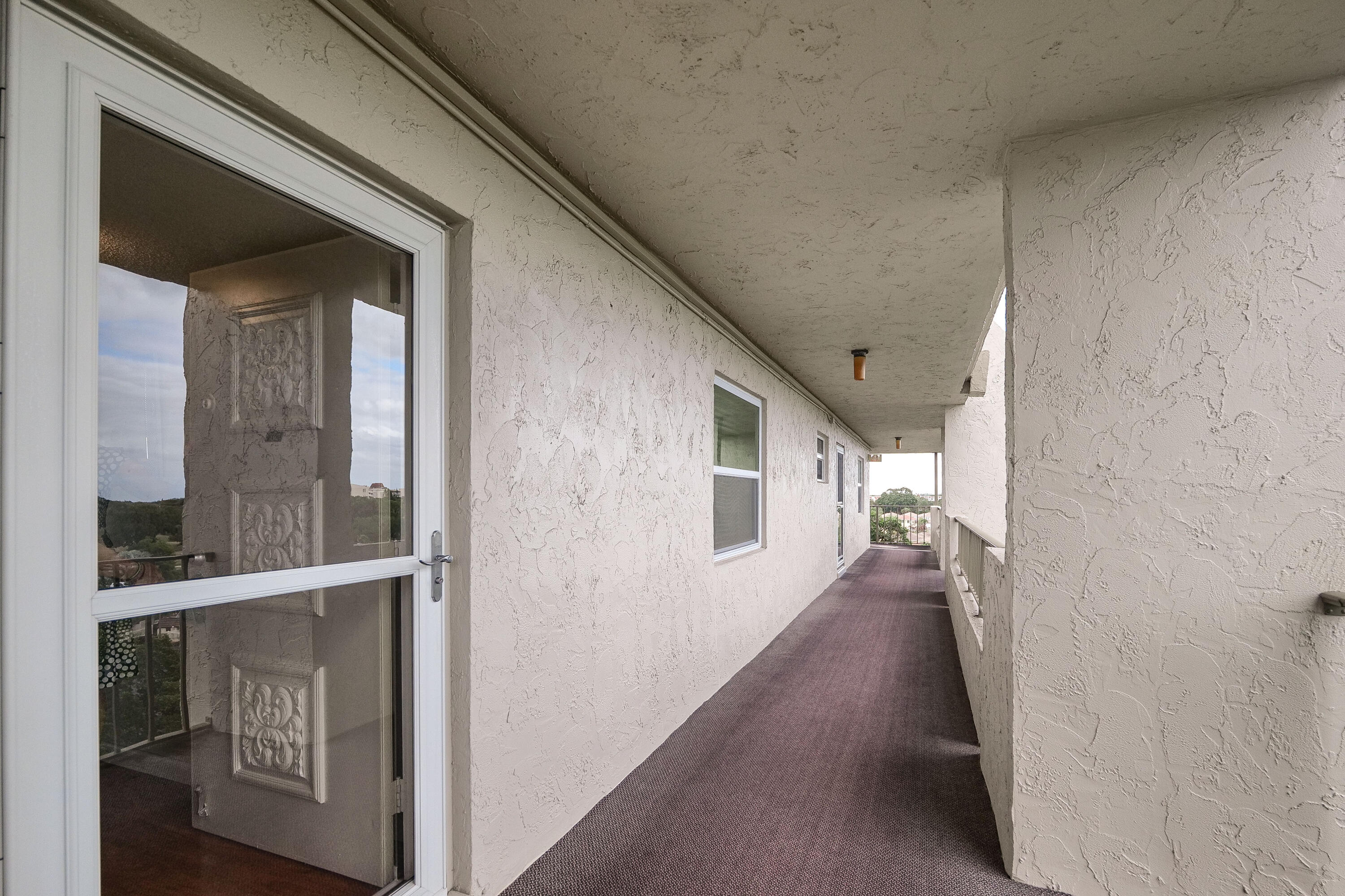 3930 Inverrary Boulevard, Unit 703D Lauderhill, FL 33319 - Photo 42 of 62 a view of a hallway with wooden floor and windows