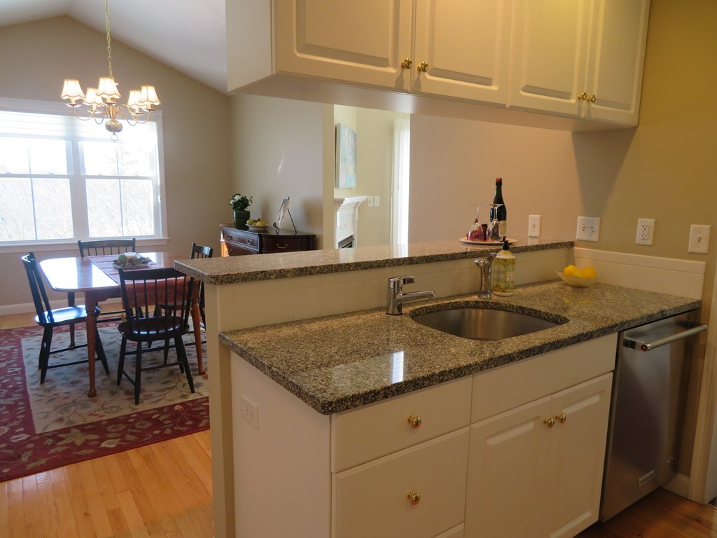 7 Strawberry Lane, Unit A Hudson, MA 01749 - Photo 2 of 20 a kitchen with a sink a table and chairs in it