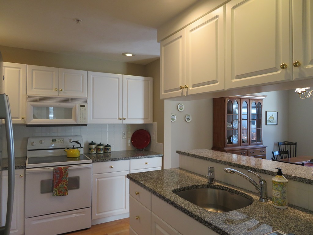 7 Strawberry Lane, Unit A Hudson, MA 01749 - Photo 3 of 20 a kitchen with stainless steel appliances granite countertop a sink a stove and cabinets