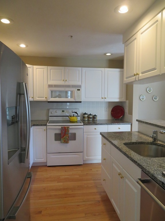 7 Strawberry Lane, Unit A Hudson, MA 01749 - Photo 4 of 20 a kitchen with granite countertop a sink stainless steel appliances and cabinets