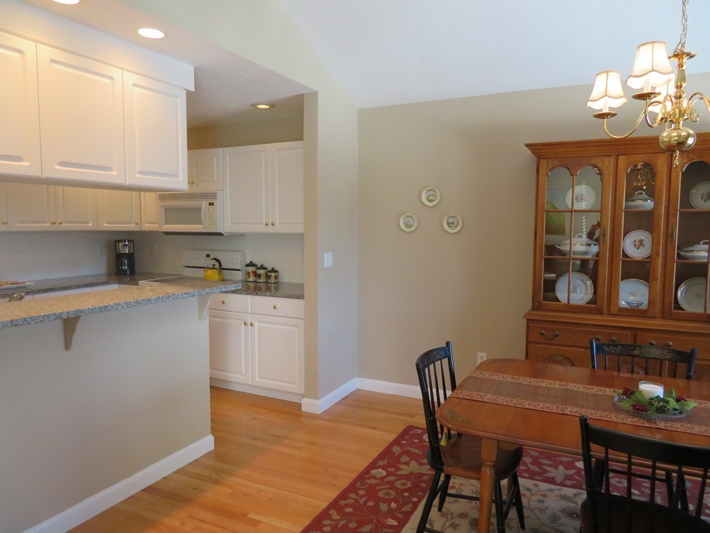 7 Strawberry Lane, Unit A Hudson, MA 01749 - Photo 5 of 20 a kitchen with stainless steel appliances granite countertop a stove top oven a sink dishwasher and white cabinets with wooden floor