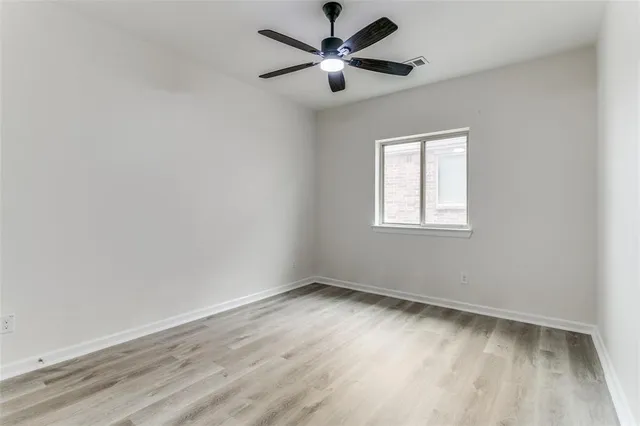 an empty room with a window and a fan
