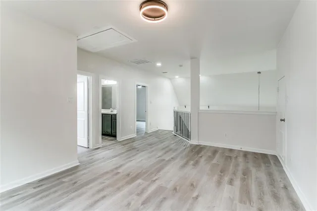 a view of an empty room with wooden floor