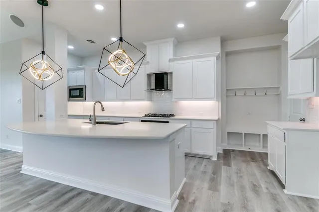 a kitchen with kitchen island white cabinets and stainless steel appliances