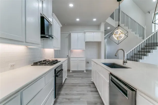 a kitchen with a sink and a stove top oven