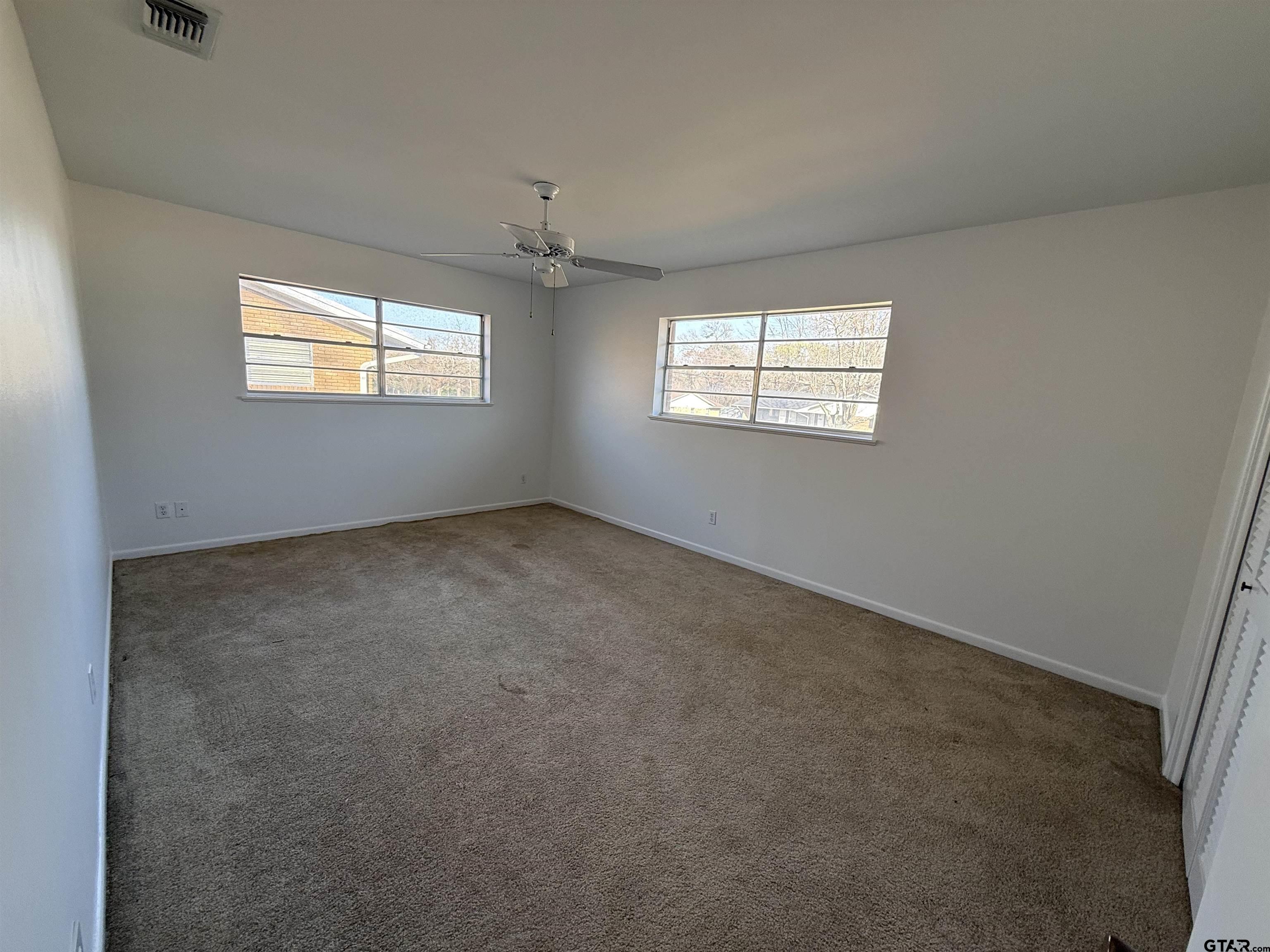 1785 Rollin Road Canton, TX 75103 - Photo 12 of 12 an empty room with windows and chandelier fan