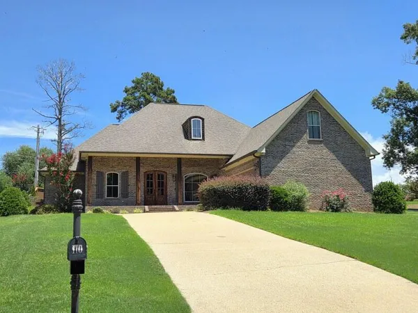a front view of a house with a garden and yard