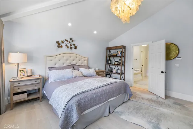 a bedroom with a bed and a chandelier