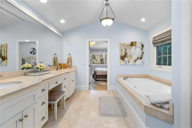 a spacious bathroom with a tub double vanity and a shower