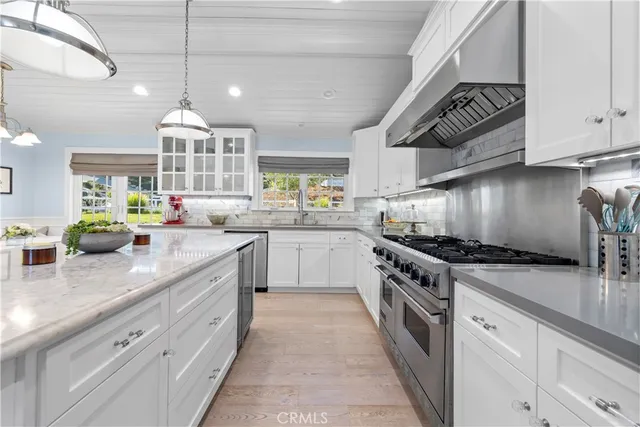 a kitchen with stainless steel appliances granite countertop a sink and a white cabinets