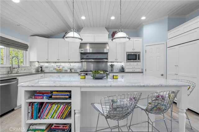 a kitchen with a dining table chairs stove and cabinets