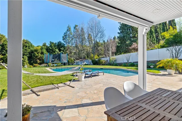 an aerial view of a house with swimming pool and outdoor seating