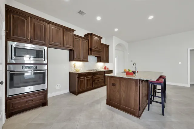 a kitchen with granite countertop a refrigerator and cabinets
