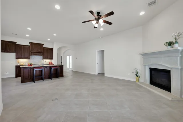 a living room with furniture and kitchen fireplace